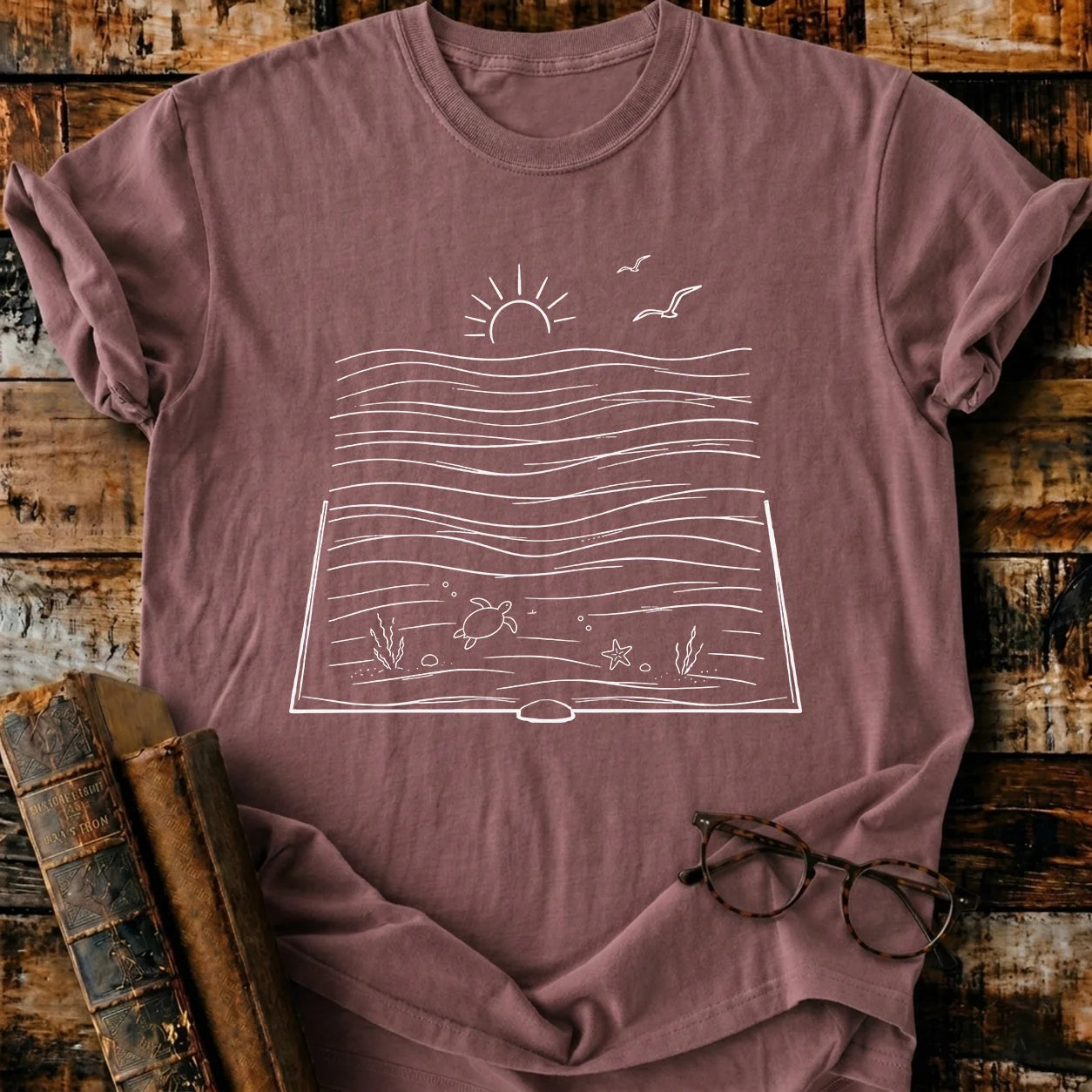 Bookish Ocean Comfort Colors T-shirt, garment-dyed, relaxed fit, with a white ocean book graphic.